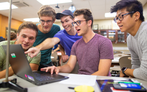 Student and faculty looking at a piece of a computer