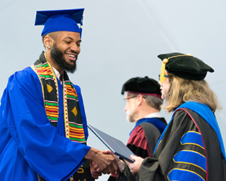 student at graduation recieving diploma