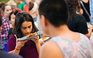 student smelling her plate of food at the international food fest