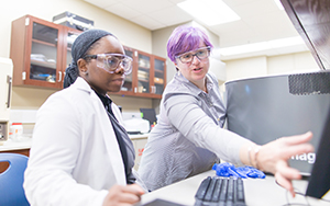 faculty and student working with lab equipment together