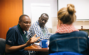 three students talking in class