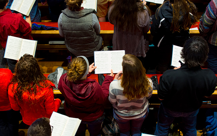 students singing from a hymnal
