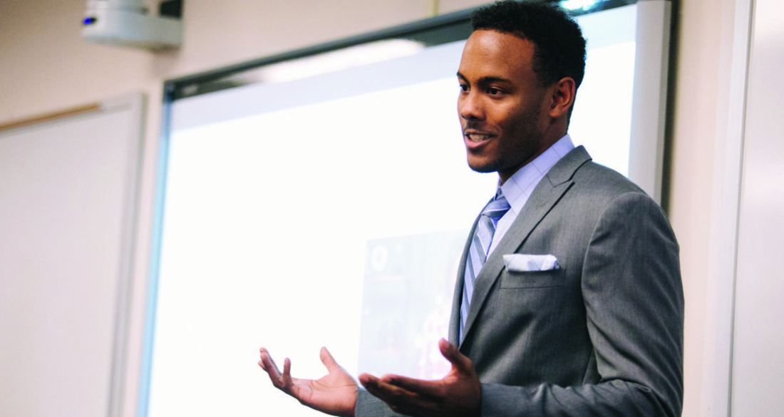 Student in suit and tie speaking in class