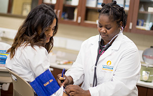student taking another student's blood pressure in a lab