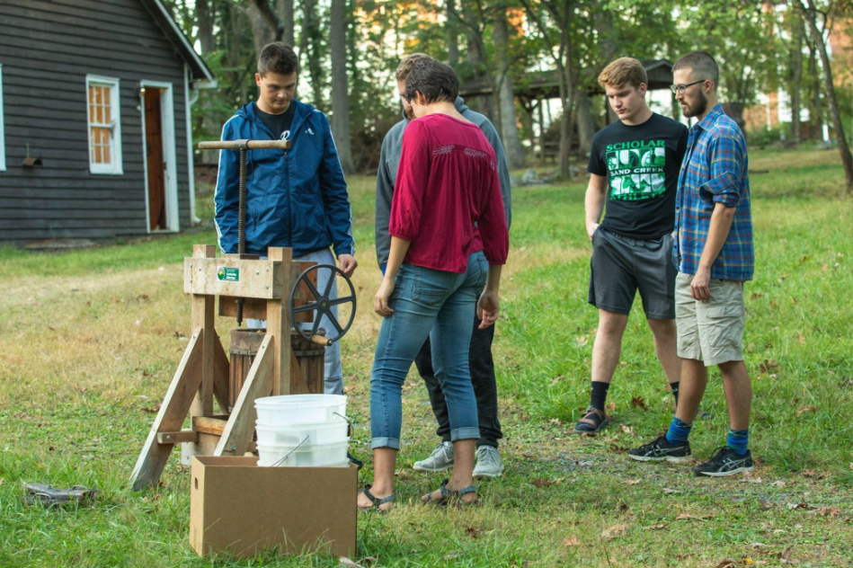 Students gathering in Park Woods to press apples for cider at a cider press