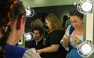 students putting on make-up in green room