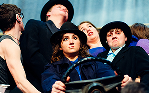 students pretending to drive a car on stage