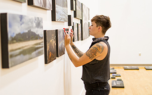 alumni hanging art in the gallery